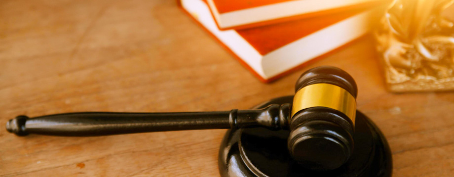 wooden gavel and books on wooden table,on brown background